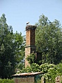 Storchennest auf dem Kamin eines verfallenen Bauernhofes dicht hinter dem Weichseldamm